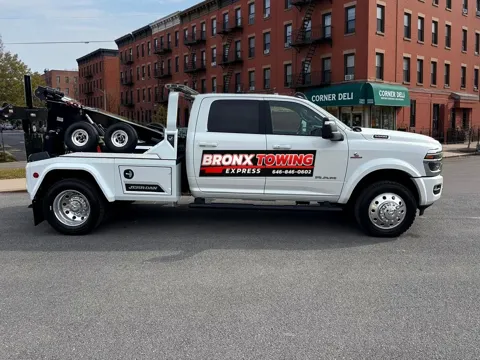 Bronx Towing Express white wrecker tow truck with company logo, side view
