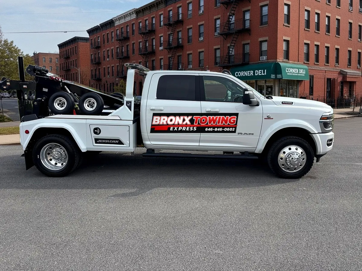 Bronx Towing Express white wrecker tow truck with company logo, side view